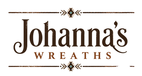 Johanna's Wreaths logo featuring dark brown serif lettering on a warm beige background with decorative horizontal lines and geometric motifs.